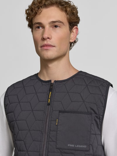 Mężczyzna nosi Regular Fit Weste in Stepp-Optik von PME Legend z mieszanki bawełny, Brustasza, zamek błyskawiczny, szare kolory, Nahaufnahme górnej części ciała. Długość tyłu w rozmiarze M: 61 cm, Szerokość ramion w rozmiarze M: 41 cm, Szerokość w rozmiarze M: 53 cm.