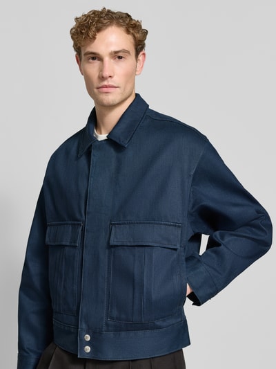 Männermodel trägt Relaxed Fit Jeansjacke aus reiner Baumwolle Modell 'HUGO 083/1' von HUGO in Dunkelblau, Nahaufnahme Oberkörper, Herren Jeansjacke von HUGO.