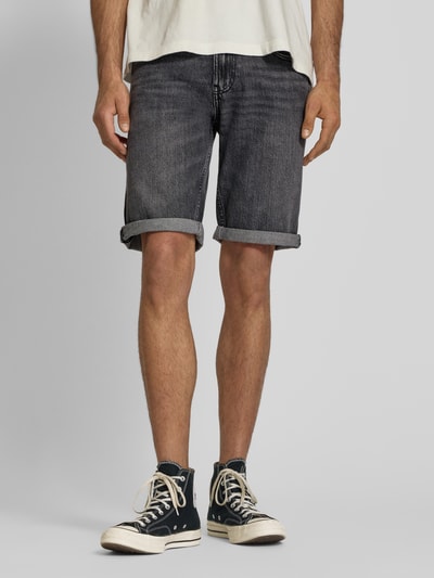 Męski model nosi Regular Fit Jeansshorts aus Baumwoll-Mix od Tommy Jeans, stylizowana na denim, naszywka z logo, wyhaftowane logo, szlufki na pasek, zapięcie na guzik i ukryty zamek błyskawiczny, 5 kieszeni, mieszanka bawełny, widok całej sylwetki z przodu