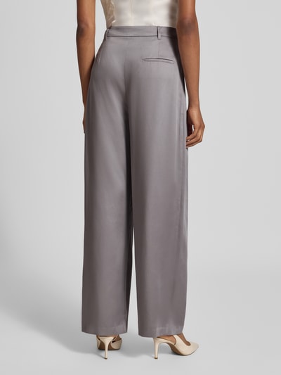 Frauenmodel trägt Wide Fit Hose aus reinem Lyocell von Liu Jo White in Grau mit asymmetrischem Design und Logo-Detail, Ganzkörperansicht Rückansicht.