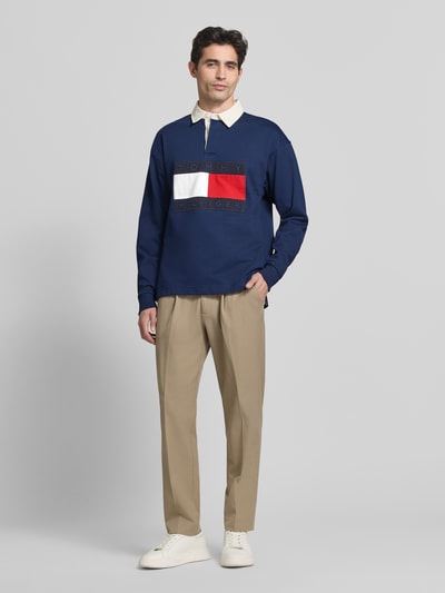 Männermodel trägt Regular Fit Sweatshirt aus reiner Baumwolle von Tommy Hilfiger, Optik: Unifarben, Label-Patch, Polokragen, Langarm, Rumpfabschluss: Geschlitzt, Materialverarbeitung: Sweat, Ganzkörperansicht von vorne.