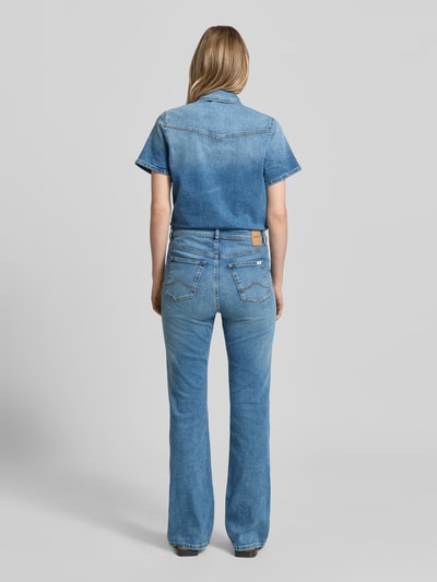 Frauenmodel trägt Flared Denim-Jumpsuit Modell 'KIMMY' von Mustang aus Baumwoll-Elasthan-Mix mit Label-Detail, Denim, blauer Farbton, Ganzkörperansicht Rückansicht.