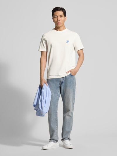 Männermodel trägt Regular Fit T-Shirt aus reiner Baumwolle von Tommy Hilfiger in Unifarben mit Logo-Stitching, Rundhals, kurzarm, Ganzkörperansicht von vorne.