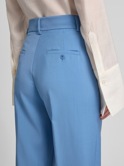 Vrouwenmodel draagt Regular Fit Bundfaltenhose aus reiner Schurwolle Modell 'VISIVO' van Weekend Max Mara in effen lichtblauw, detailopname rugzijde, zijde-ingangzakken en knoopsluiting, pure scheerwol.