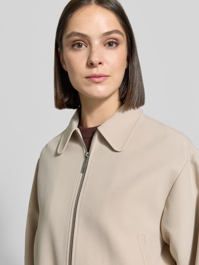 Frauenmodel trägt Regular Fit Jacke mit Viskose-Mix von MORE & MORE in Beige, glatte Textur, Umlegekragen, Nahaufnahme Oberkörper.