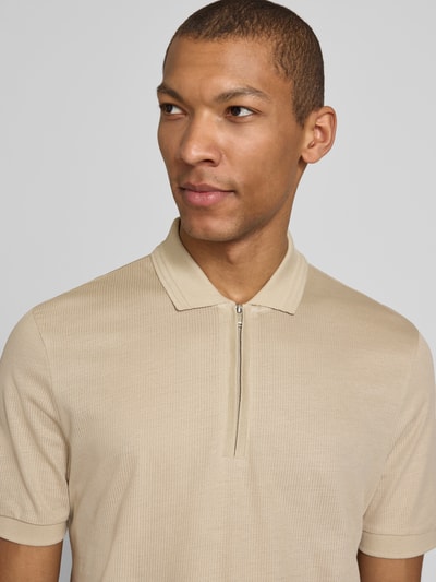 Männermodel trägt Regular Fit Poloshirt aus Baumwoll-Lyocell-Mix Modell 'H-PARAS 70' von BOSS in Beige, Piqué, Nahaufnahme Oberkörper.