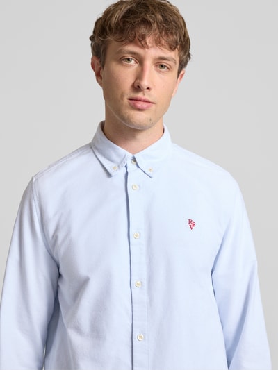 Männermodel trägt Regular Fit Freizeithemd mit Button-Down-Kragen und Stitching von REVIEW in Hellblau, reine Baumwolle, Nahaufnahme Oberkörper. Rückenlänge 43 cm, Schulterbreite 54 cm, Ärmellänge 67 cm, Label-Stitching.