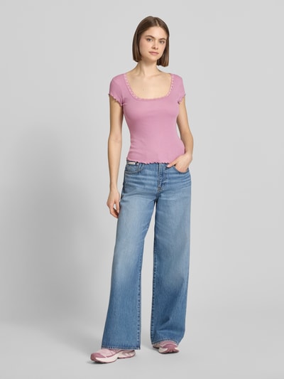 Frauenmodel trägt Slim Fit T-Shirt aus Viskose-Mix mit Spitzenbesatz von Review in Rosa, schmale Form, Rundhalsausschnitt, Ganzkörperansicht von vorne.