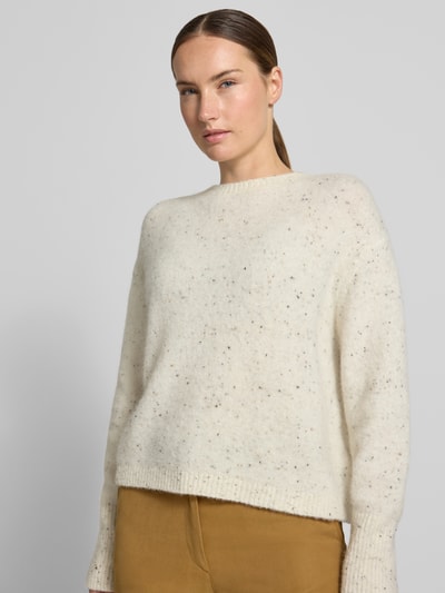 Vrouwenmodel draagt wollige, gebroken witte wollen trui uit Alpacamix Model 'ALCALI' van Marella, losse pasvorm, ribboorden, dames, geribd oppervlak, detailrijke textuur, ruglengte maat S 52 cm, mouwlengte 56 cm, Nahaufnahme Oberkörper.
