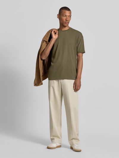 Männermodel trägt T-Shirt mit Ärmelaufschlag und Rundhalsausschnitt von Drykorn aus Reine Baumwolle in Regular-Fit, Ganzkörperansicht von vorne.