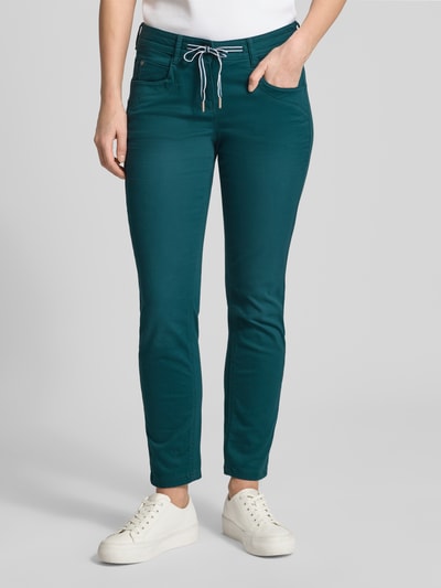 Frauenmodel trägt Tapered Chino aus Baumwoll-Mix von Tom Tailor in Türkis, unifarben, 5-Pocket-Design, Nahaufnahme Oberkörper bis Beine.