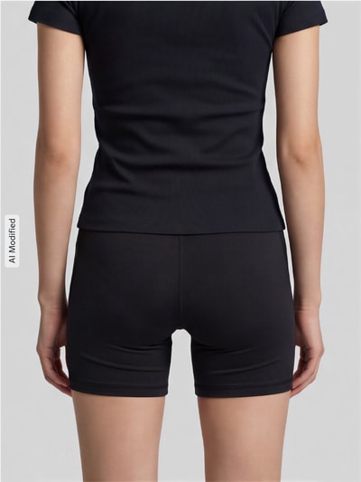 Frauenmodel trägt Elastische Sportshorts mit Logo-Print Modell 'PUMA X HYROX ESS SHORT' von PUMA in Schwarz, Damen Sportshorts, Ganzkörperansicht Rückansicht, KI-modifiziertes Bild.