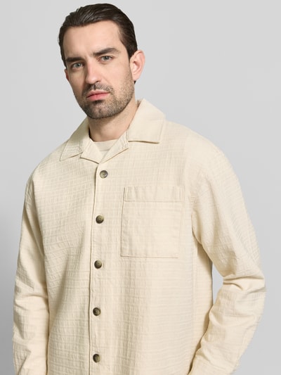 Männermodel trägt Relaxed Fit Freizeithemd aus reiner Baumwolle Modell 'RLXRAY' von SELECTED HOMME in Beige, Struktur, Nahaufnahme Oberkörper.