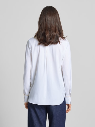 Modelka nosi bluzkę z mieszanki jedwabiu z nadrukiem z motywem Bluse aus Seiden-Mix mit Motiv-Print von HERZENS, biały kolor, krój loose fit, kołnierzyk koszulowy, dekolt w serek, dłuższy tył, rękawy długie 60 cm, długość tyłu 69 cm w rozmiarze 36, widok całej sylwetki z tyłu.