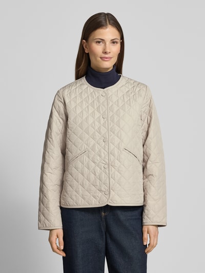 Modelka nosi Regular Fit Steppjacke mit Label Stitching Modell 'CASHEL' od Barbolur, efekt: jednolity kolor, krój regular fit, listwa z zatrzaskami, wyhaftowane logo, długi rękaw, jasnobeżowa, tekstura pikowana, widok całej sylwetki z przodu.