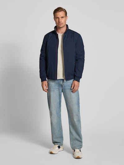 Männermodel trägt Regular Fit Jacke mit Stehkragen von Christian Berg Men in Dunkelblau, Reißverschluss, Eingrifftaschen, Ganzkörperansicht von vorne