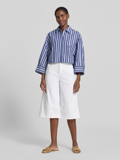 Frauenmodel trägt Bermudas im 5-Pocket-Design Modell 'Liv' von Angels aus weißem Baumwoll-Mix mit Wide Leg Fit, Ganzkörperansicht von vorne.