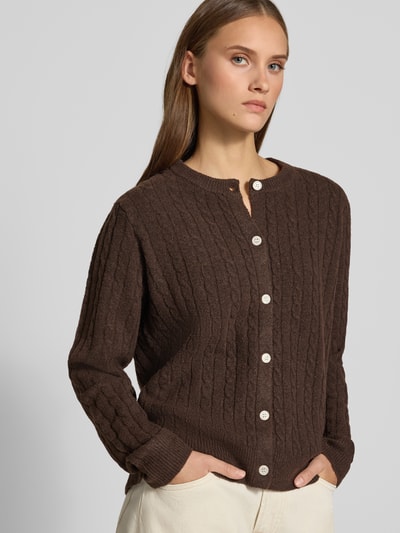 Frauenmodel trägt Regular Fit Strickjacke mit Woll-Anteil Modell 'SILLY' von PIECES, braun, Strukturstrick mit Knöpfen, Nahaufnahme Oberkörper. Damen Strickjacke.