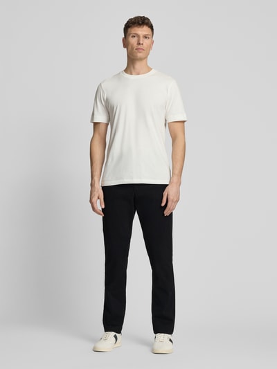 Männermodel trägt Slim Fit Chino mit Eingrifftaschen von GAP in Schwarz aus Baumwoll-Elasthan-Mix, Ganzkörperansicht von vorne.