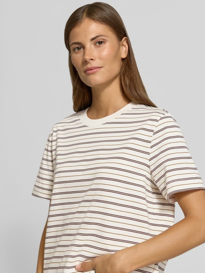 Frauenmodel trägt Boxy Fit T-Shirt aus reiner Baumwolle Modell 'ESSENTIAL' von Selected, cremefarben mit braunen Streifen, Damen T-Shirt, Nahaufnahme Oberkörper.