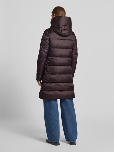 Frauenmodel trägt Steppmantel mit Kapuze Modell 'LYSA' von Save The Duck in dunklem Braun, gesteppte Oberfläche, Ganzkörperansicht Rückansicht. Gerader Schnitt, Zweiwege-Reißverschluss, Label-Patch, seitliche Eingrifftaschen, Rücklänge bei Größe S 91 cm, Schulterbreite 39 cm, Brustweite 40 cm, Ärmellänge 66 cm.