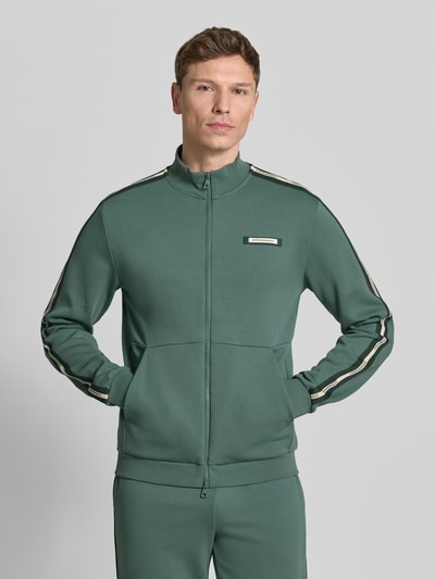 Männermodel trägt Sweatjacke mit Stehkragen und Zweiwege-Reißverschluss von EA7 Emporio Armani in Grün, Regular Fit, Ganzkörperansicht von vorne