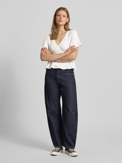 Frauenmodel trägt Regular Fit Bluse in Wickel-Optik Modell 'PELLY' von Only, Optik: Unifarben, Allover-Muster, Struktur, kurzarm, mit Bindegürtel und tiefem V-Ausschnitt, Ganzkörperansicht von vorne.