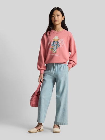 Dziewczynka nosi Regular Fit Sweatshirt aus Baumwoll-Mix mit BEAR-Motiv od Polo Ralph Lauren Teens, efekt: jednolity kolor, nadruk polo bear, z napisem z logo, okrągły dekolt, długi rękaw, prążkowane zakończenia rękawów i dołu, wykończenie materiału: dzianina dresowa, mieszanka bawełny, całkowity widok z przodu.