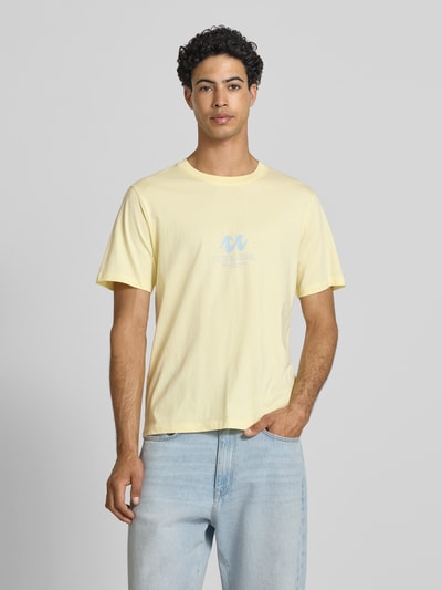 Männermodel trägt Regular Fit T-Shirt mit Logo-Print Modell 'Eres' von Jack & Jones in Gelb, reine Baumwolle, Rundhalsausschnitt, Ganzkörperansicht von vorne.