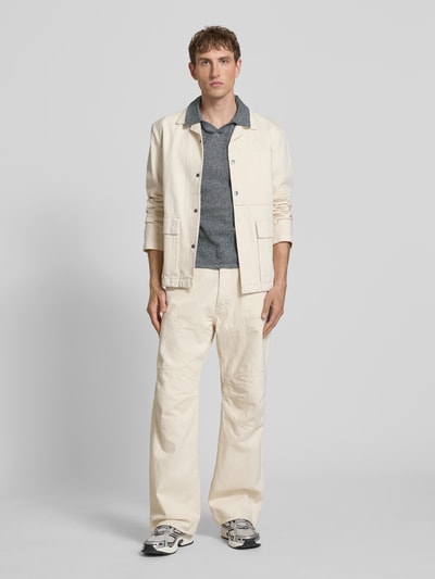 Männermodel trägt Regular Fit Strick-Poloshirt Modell 'CASSIS' von Jack & Jones aus reiner Baumwolle in Grau, Ganzkörperansicht von vorne.