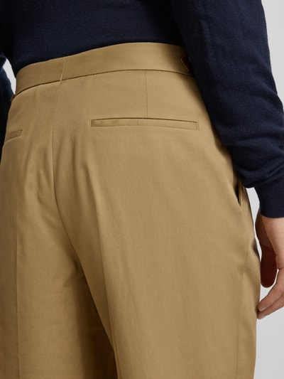 Männermodel trägt Tapered Bundfaltenhose aus Baumwoll-Mix Modell 'PERINO' von BOSS, Optik: Unifarben, Nahaufnahme Rückansicht.