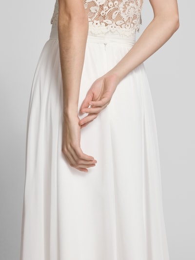 Modelka nosi Midirock aus Chiffon mit Reißverschluss von Luxuar, kremowy kolor, tkanina zwiewna, A-linia, detal zamka, Szerokość w rozmiarze 36: 38 cm, Długość całkowita w rozmiarze 36: 77 cm, zdjęcie z tyłu, ujęcie detailowe pleców i talii.