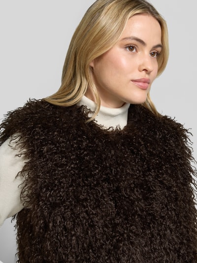 Frauenmodel trägt Regular Fit Weste aus Kunstfell von MICHAEL Michael Kors, dunkelbraun, weiche lockige Textur, Nahaufnahme Oberkörper. Damen Weste, Rundhalsausschnitt, ärmellos, Rückenlänge 56 cm bei Größe S, Schulterbreite 37 cm, Brustweite 32 cm.