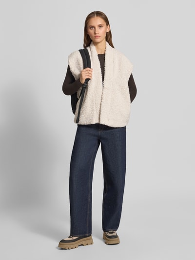Modelka nosi beżową kamizelkę o kroju regular fit z imitacją futerka Regular Fit Weste in Teddy-Optik Modell 'NAYA' od ONLY, damska kamizelka, całopostaciowy widok z przodu.