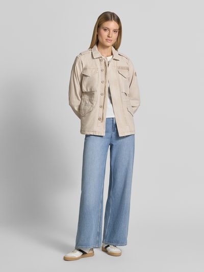 Frauenmodel trägt Regular Fit Jacke mit Umlegekragen Modell 'Buni' von khujo in Beige, reine Baumwolle, mit Logo-Stitching, aufgesetzte Taschen, Ganzkörperansicht von vorne.