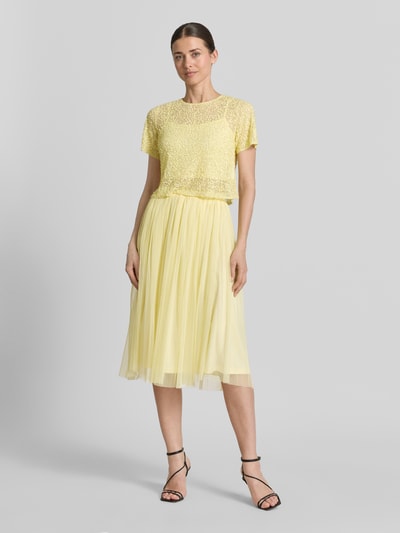 Frauenmodel trägt Cropped T-Shirt mit Pailletten von LACE & BEADS, Damen T-Shirt aus Mesh, Rundhalsausschnitt, Rückenlänge 41 cm, Farbe Gelb, Ganzkörperansicht von vorne.