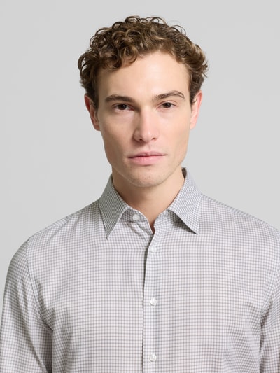 Męskimodel nosi Slim Fit Business Koszula z bawełny z kołnierzykiem typu button down od SEIDENSTICKER, lista guzikowa, zbliżenie górnej części ciała. Długość tyłu 78 cm, szerokość ramion 42 cm, długość rękawów 65 cm, wzór w kratkę, odcienie szarości i bieli.
