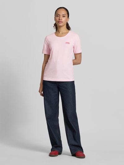 Kobiece model prezentuje damski t-shirt z bawełny, krój regular fit, okrągły dekolt, wyhaftowany napis, Christian Berg Woman, długość tyłu 59 cm w rozmiarze S, widok całej sylwetki z przodu