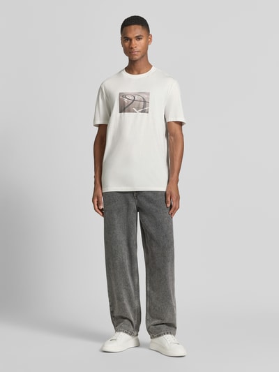 Männermodel trägt Relaxed Fit T-Shirt aus reiner Baumwolle Modell 'DOSTINO' von HUGO, Optik: Unifarben, Label-Print, Ganzkörperansicht von vorne.