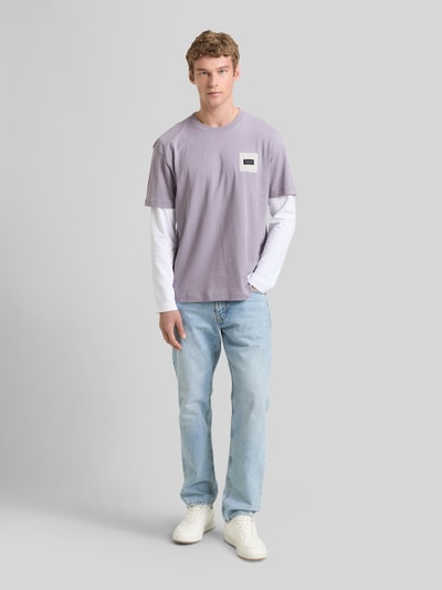 Mannelijk model draagt Relaxed Fit T-Shirt uit pure katoen van Tom Tailor Denim, effen, labelprint, ronde hals, korte mouw, voorkant volledige lichaamsweergave