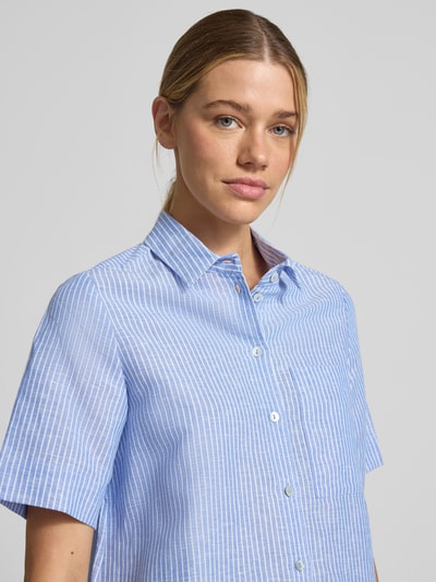 Frauenmodel trägt Regular Fit Leinenbluse mit Hemdblusenkragen von Christian Berg Woman, feine blaue und weiße Streifen, reine Leinen, Knopfleiste, Rückenlänge 61 cm, Ärmellänge 28 cm bei Größe 36, Nahaufnahme Oberkörper.