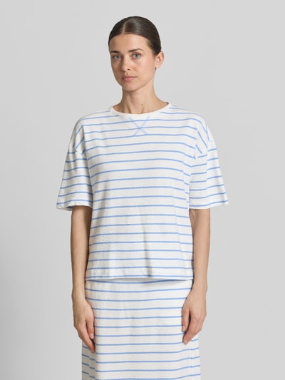 Modelka kobieca nosi Regular Fit T-Shirt mit Rundhalsausschnitt von Smith and Soul, bawełna, krój regular fit, ramiona opadające, długość tyłu w rozmiarze S: 56 cm, białe i niebieskie paski, widok całej sylwetki z przodu