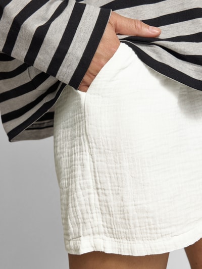 Frauenmodel trägt Relaxed Fit Shorts aus reiner Baumwolle Modell 'THYRA' von Only, Optik: Unifarben, Crêpe-Textur, seitliche Eingrifftaschen, Nahaufnahme Oberkörper.