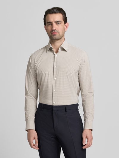 Męski model nosi Regular Fit Businesshemd mit Kombimanschette Modell 'P-JOE-K' od BOSS, beżowa drobna kratka, krój regular fit, koszula biznesowa, długi rękaw, kent, guziki, widoczny label stitching, gładka faktura, całkowity widok z przodu.