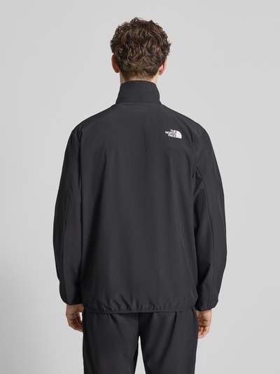 Męski model nosi Regular Fit Jacke mit Stehkragen Modell 'Mountain' von The North Face, czarny kolor, elastyczna mieszanka materiałów, nadruk z logo, zamek błyskawiczny, wpuszczane kieszenie, elastyczne wykończenia, długość tyłu w rozmiarze M: 73 cm, szerokość ramion w rozmiarze M: 43 cm, szerokość klatki piersiowej w rozmiarze M: 56 cm, długość rękawów w rozmiarze M: 70 cm, widok całej sylwetki z tyłu