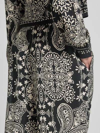 Frauenmodel trägt Loose Fit Weite Hose aus reiner Viskose Modell 'EMZA AJA' von Only, Optik: Allover-Muster, florale Details, Popeline, Nahaufnahme Hüfte und seitliche Eingrifftasche.