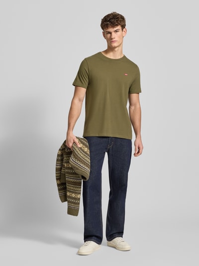 Männermodel trägt T-Shirt mit Label-Stitching von Levi's®, olivgrün, Reine Baumwolle, Regular-Fit, Rundhalsausschnitt, Ganzkörperansicht von vorne.