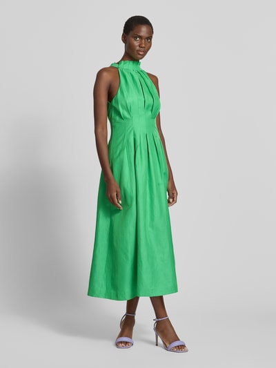 Frauenmodel trägt Cocktailkleid mit Drapierungen Modell 'Miller' von Forever New, Viskose-Leinen-Mix, A-Linie, Midikleid, Ganzkörperansicht von vorne.