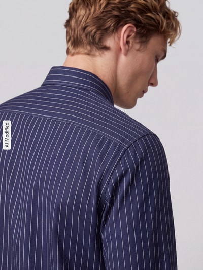 Männermodel trägt Slim Fit Businesshemd aus reiner Baumwolle von Jake*s, dunkelblau mit weißen Streifen, Ganzkörperansicht Rückansicht, KI-modifiziertes Bild.