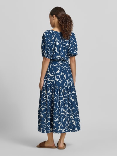Frauenmodel trägt Midikleid aus Viskose-Baumwoll-Mix mit V-Ausschnitt von Zero, Allover-Print in Blau-Weiß, Bindegürtel, Ganzkörperansicht Rückansicht.